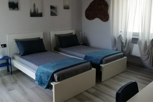apartment with two single beds, a kitchenette, and a private bathroom.
