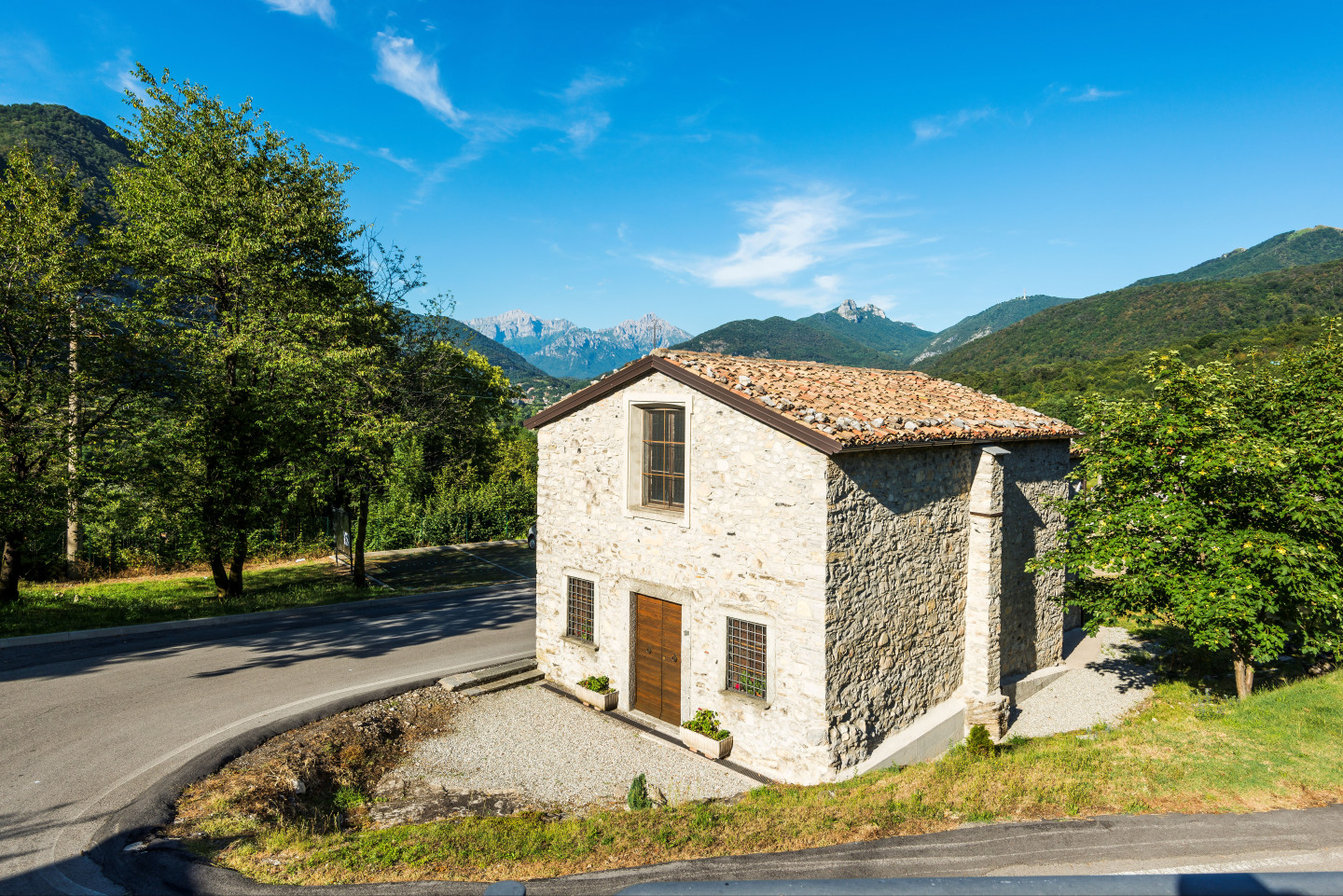 L'esterno della chiesa è realizzato in pietra, presenta una facciata a capanna con il portale principale e tre finestre