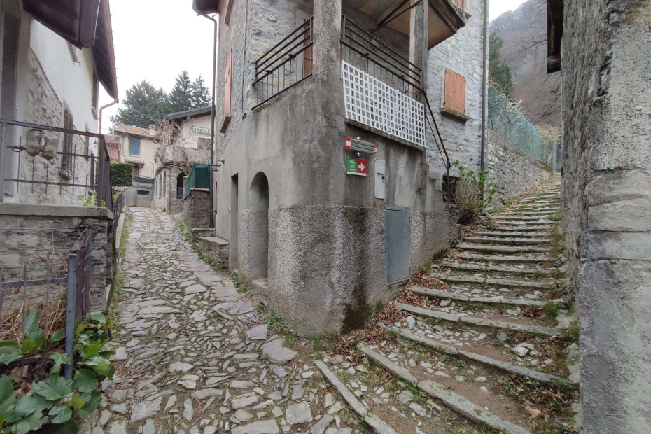 La scalinata in sassi sale tra gli edifici