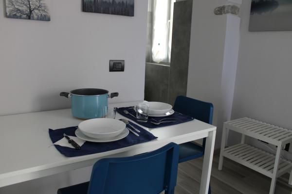 apartment with two single beds, a kitchenette, and a private bathroom.